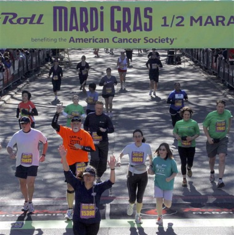Writer Karen Schwartz, foreground right in white shirt, crosses the finish line with her daughter, who joined her at the end of the race and helped her to the medical tent at the Rock 'n' Roll Mardi Gras Half Marathon in New Orleans.